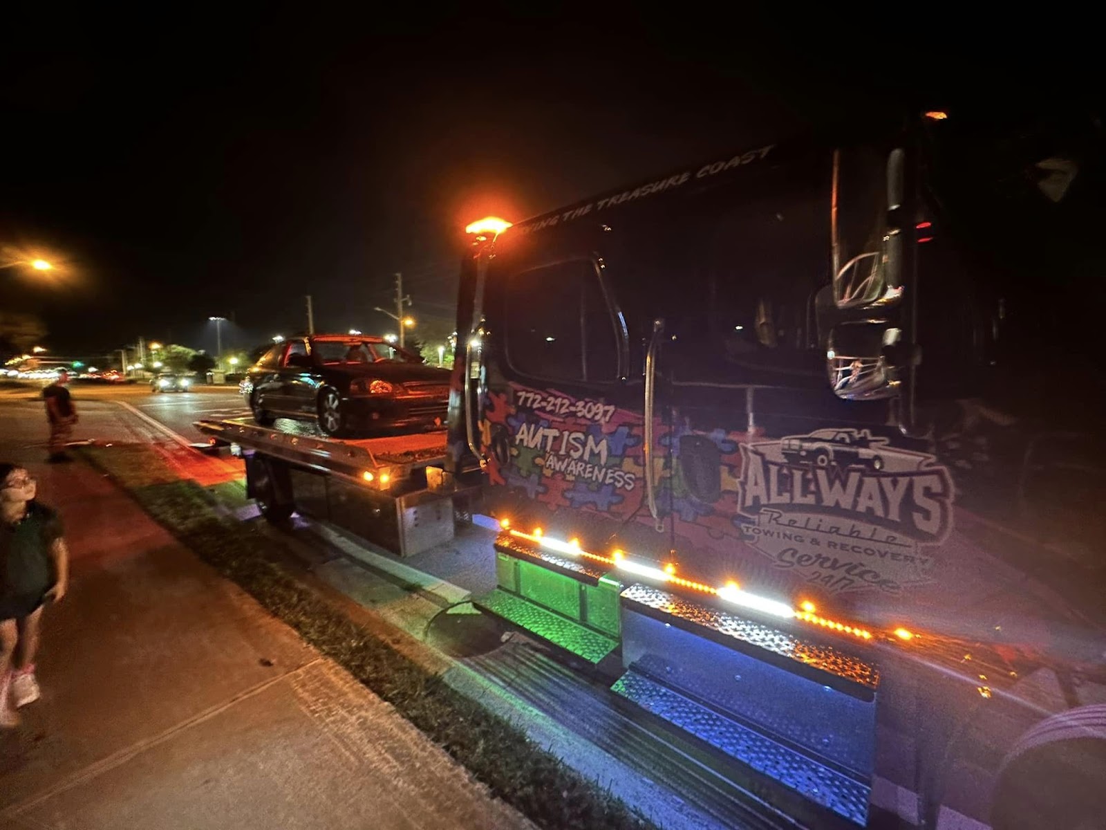AllWays Reliable Towing branded tow truck at night with vehicle loaded Fort Pierce FL